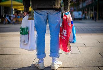 Mann mit Plastiktüten in der Fußgängerzone
