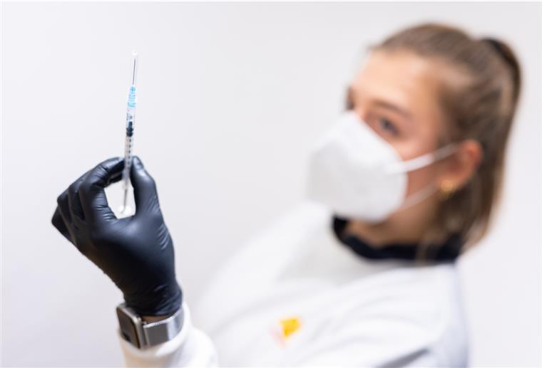 Die Mitarbeiterin eines Impfzentrums hält eine Spritze mit Biontech-Impfstoff in ihrer Hand. 