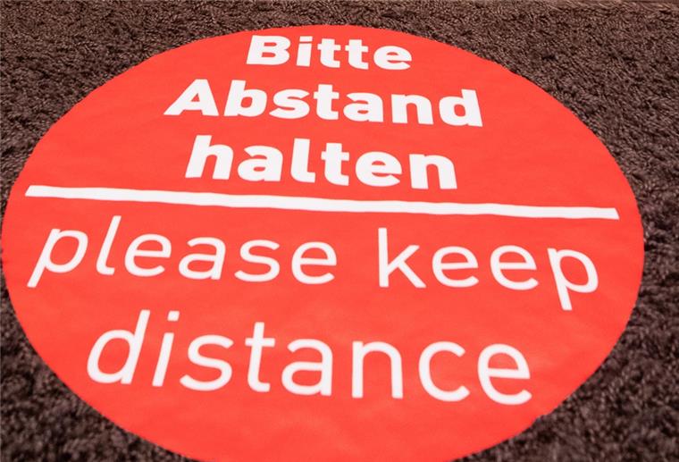 Bremerhaven: Hochzeitsgesellschaft sorgt für Aufsehen Rotes Schild auf Fußboden, Abstand halten
