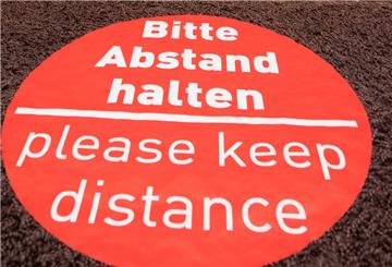Rotes Schild auf Fußboden, Abstand halten