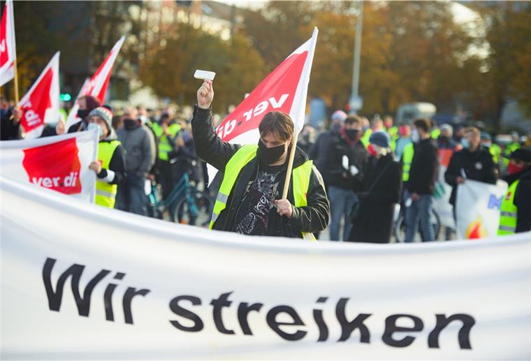 Menschen streiken in Warnweste und mit ver.di-Fahnen. 