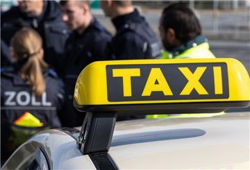 Zollmitarbeiter kontrollieren Taxifahrer.