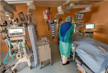 Chefarzt Lorenz Nowak untersucht in Schutzkleidung in einem Intensivbett-Zimmer in der Asklepios Klinik einen geheilten Corona-Patienten, der von der Beatmungsmaschine entwöhnt werden muss.