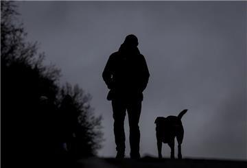 Ein Mann läuft mit seinem Hund bei Nieselregen über den Osterdeich.