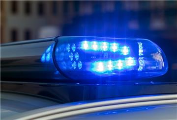 Das Blaulicht auf einem Fahrzeug der Polizei leuchtet in der Dunkelheit.