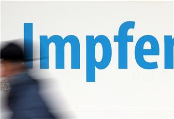 Ein Mann geht vor einem Impfzentrum in der Innenstadt. 