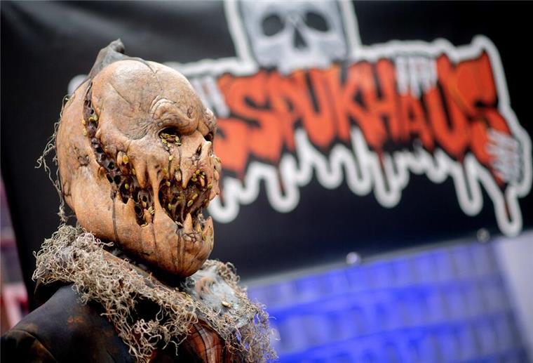  Eine Figur steht im Eingangsbereich vor einem Banner der temporären Attraktion «Das Spukhaus 2023». 
