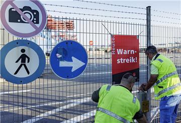 Hafenarbeiter hängen am Zaun der Containerterminals der HHLA (Hamburger Hafen und Logistik AG) ein Schild mit der Aufschrift „Warnstreik“ auf.