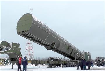 Eine riesige Abschussvorrichtung für eine Rakete ist umringt von einigen Soldaten.
