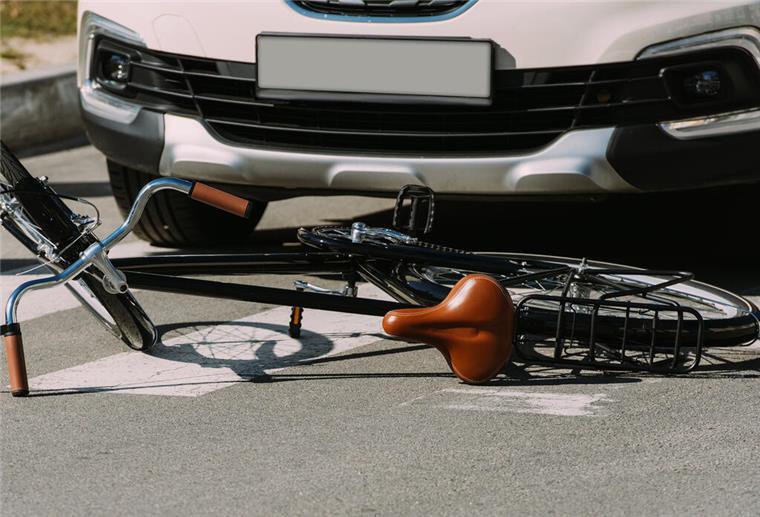 Immer mehr Radfahrer werden Unfallopfer close up view of broken bicycle and car on road, car accident concept