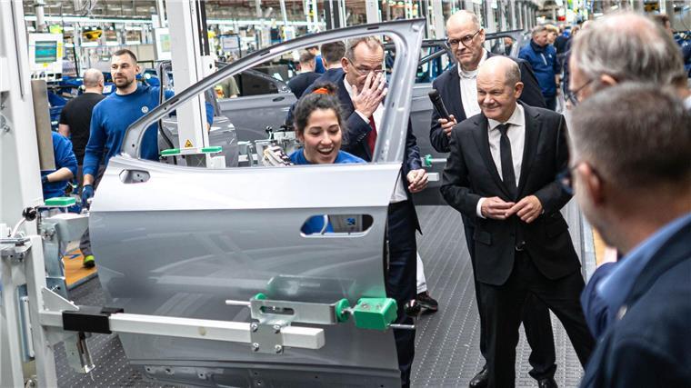 In der Halle lässt sich Scholz während eines Rundgangs die Fertigung von E-Autos zeigen.