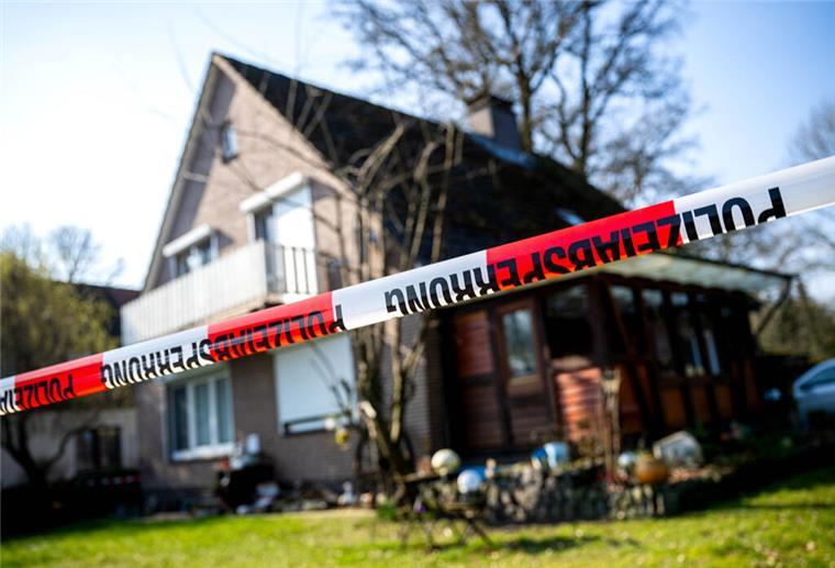 Absperrband der Polizei hängt vor einem Einfamilienhaus.