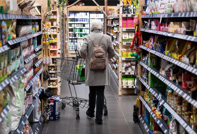 Eine Frau geht mit ihrem Einkaufswagen durch einen Supermarkt. In vielen Supermärkten stehen Produkte auf dem Kopf - und das nicht ohne Grund.