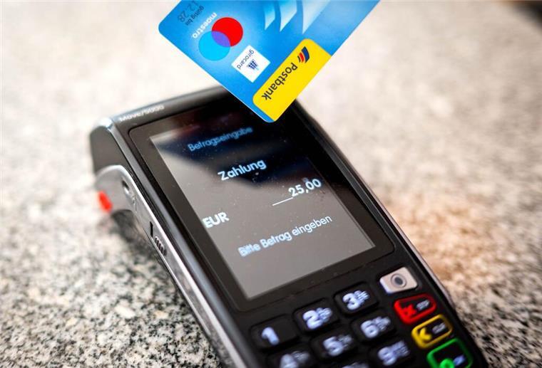 Bargeld oder Karte? Was Händler wirklich ablehnen dürfen Ein Kartenlesegerät wo jemand mit Karte eine Summe von 25 Euro zahlt.