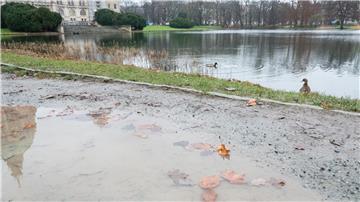 In einer Pfütze spiegelt sich ein Teil des Rathauses Hannover wider.