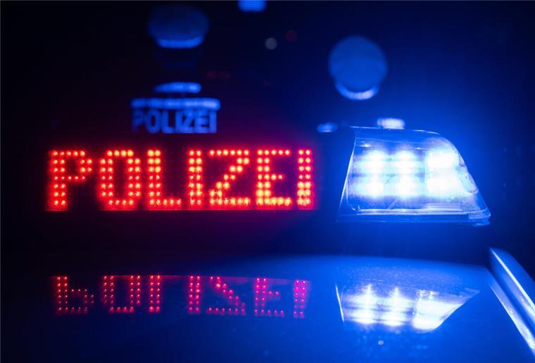 Dank aufmerksamer Zeugin: Ladendiebin auf frischer Tat ertappt Zwei Polizisten stehen vor einem Polizeifahrzeug.