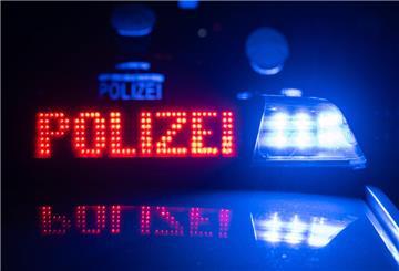 Zwei Polizisten stehen vor einem Polizeifahrzeug.