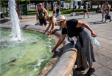 Griechenland: Touristen erfrischen sich bei Temperaturen über 40 Grad mit Wasser aus einem Brunnen auf dem Syntagma-Platz.