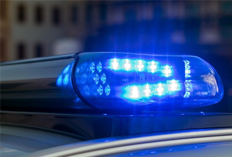 Das Blaulicht auf einem Fahrzeug der Polizei leuchtet in der Dunkelheit. 