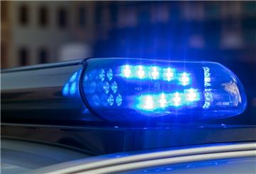Das Blaulicht auf einem Fahrzeug der Polizei leuchtet in der Dunkelheit. 