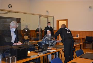 In Handschellen wurde der Angeklagte (Mitte) zum Prozessauftakt in den Gerichtssaal in Stade geführt. Ihm wird vorgeworfen, im November einen 34-Jährigen erschossen zu haben. Zum Prozessauftakt äußerte der Angeklagte sich nicht.