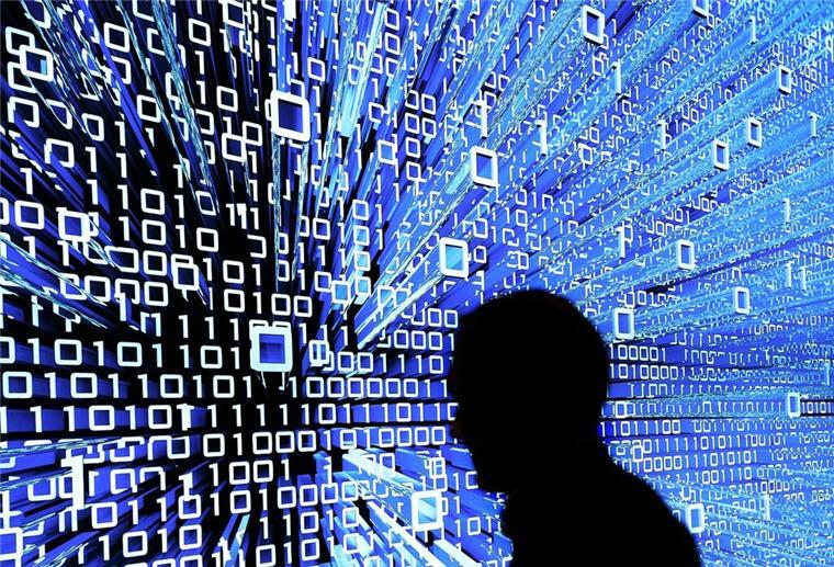 Schock-Umfrage! KI bedroht unsere Arbeitsplätze Ein Messebesucher geht in Hannover an einem Leuchtdisplay auf der CeBIT vorbei.