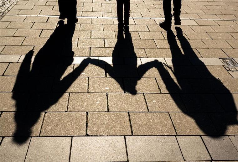 Kindergeld zurückzahlen: In diesen Fällen fordert die Familienkasse Geld zurück Die Schatten von zwei Erwachsenen und einem Kind fallen in den Morgenstunden auf den Asphalt.