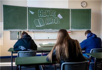 Drei Schüler sitzen im Klassenzimmer und an der Tafel steht "Heute Abitur"