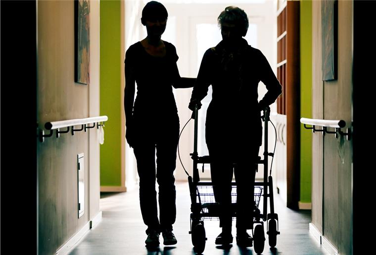 Frau an Rollator in Pflegeheim