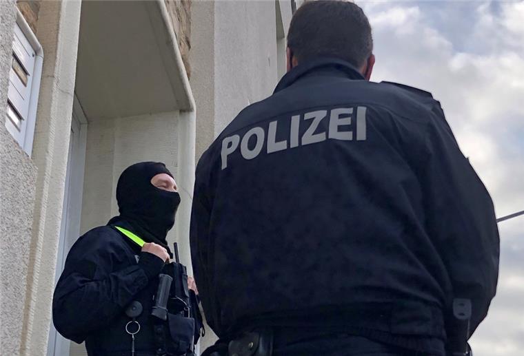 Polizei durchsucht mehrere Wohnungen im Norden Polizisten stehen im Rahmen einer Durchsuchung vor einem Wohnhaus.