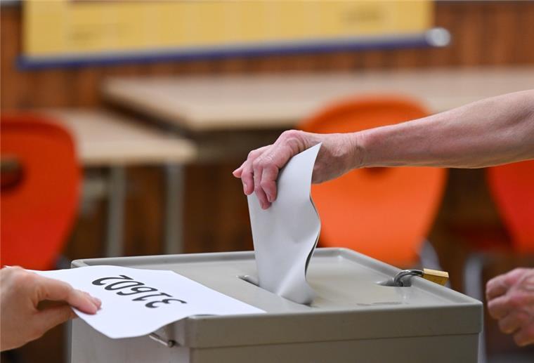 Eine Frau wirft bei der Stimmabgabe für die Oberbürgermeisterwahl in einem Wahllokal den Stimmzettel in die Wahlurne.
