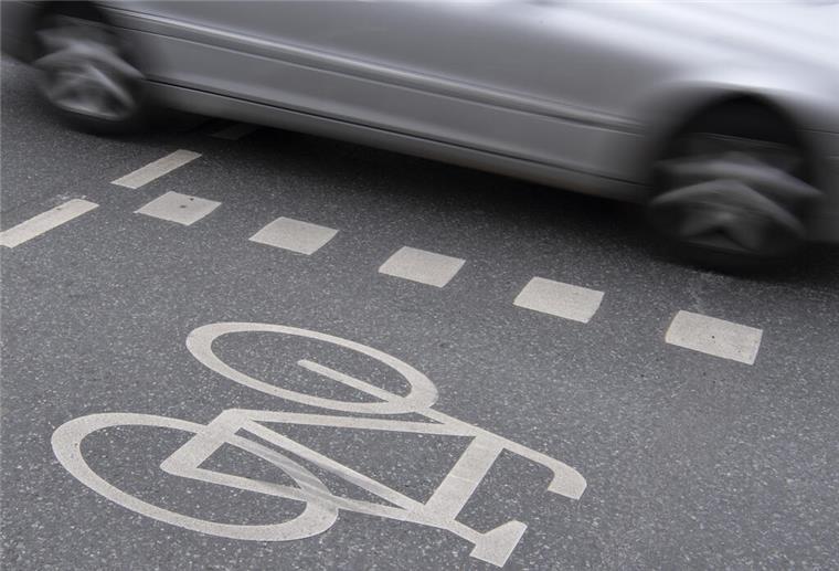 09.04.2019, Hessen, Frankfurt/Main: Ein Auto fährt an einer Kreuzung in der Innenstadt an einem Radweg vorbei. In Hessen ist Fahrradfahren in Frankfurt am gefährlichsten. Im vergangenen Jahr ereigneten sich in Hessens größter Kommune die meisten Radunfälle, wie aus dem Jahresbericht des Statistischen Landesamts hervorgeht. Foto: Boris Roessler/dpa +++ dpa-Bildfunk +++