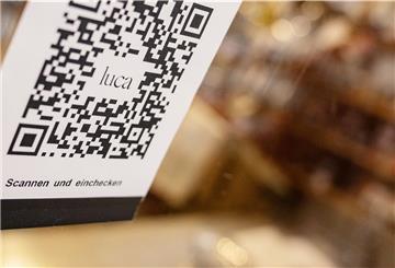 Ein Barcode, der mit der Luca-App zur Kontaktnachverfolgung gescannt werden kann, hängt in einem Einzelhandelsgeschäft an einer Schutzscheibe.