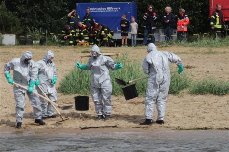 Große Übung: Öl-Alarm auf der Weser In Schutzanzügen übten die Einsatzkräfte das Reinigen des Strands.