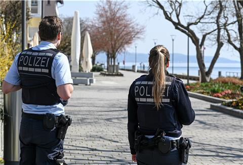 In Überlingen am Bodensee kontrollieren zwei Polizisten die normalerweise sehr gut besuchte und aktuell gesperrte Uferpromenade.