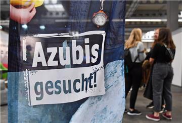 Das Schild Azubis gesucht steht auf einer Messe.