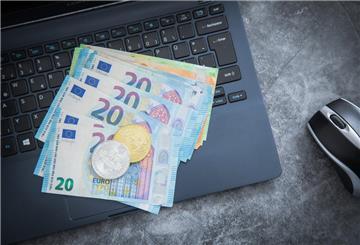 Geld liegt auf einem Laptop. In volatilen Börsenzeiten prüfen viele Anleger einen Depotwechsel – der richtige Zeitpunkt kann entscheidend sein. Ein Vergleich der Anbieter spart oft bares Geld.