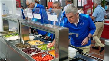 IOC-Präsident Thomas Bach (r) testete auch das Essen im olympischen Dorf.