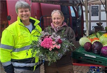Zwei Menschen mit einem Blumenstrauß. 