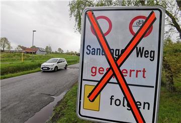 Straße mit Auto, daneben ein Hinweisschild