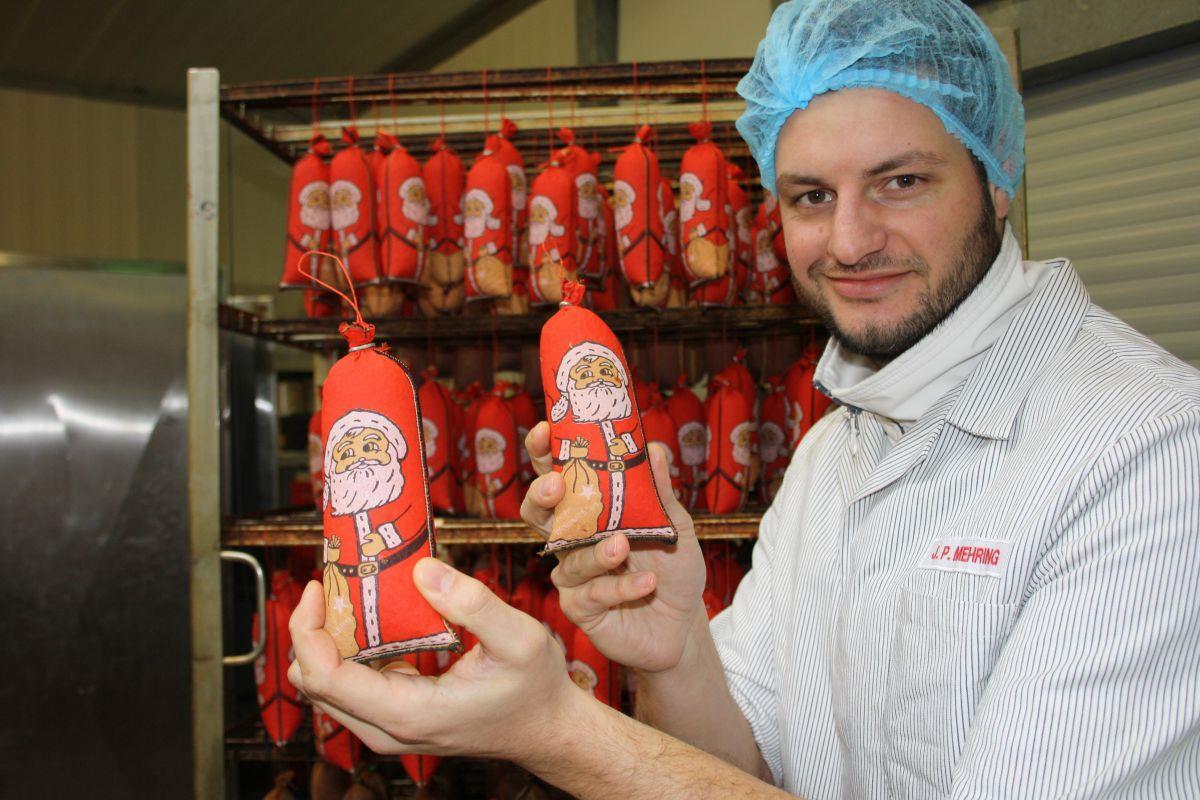 Jan-Peter Mehring zeigt die Bauernmettwurst im Weihnachtsmann-Mantel.  