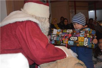 Jedes Kind bekam ein Geschenk vom Weihnachtsmann. Die Augen der Kleinen leuchteten, als sie das Präsent entgegennahmen. 