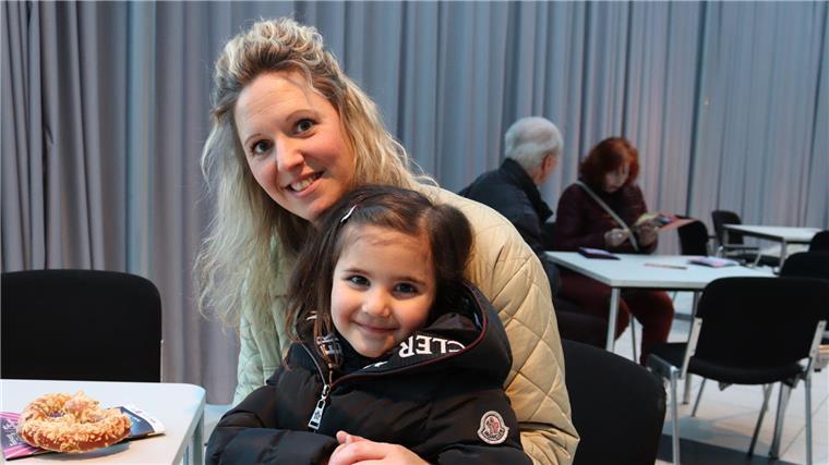 Frau mit blonden Haaren und Kind auf Schoß