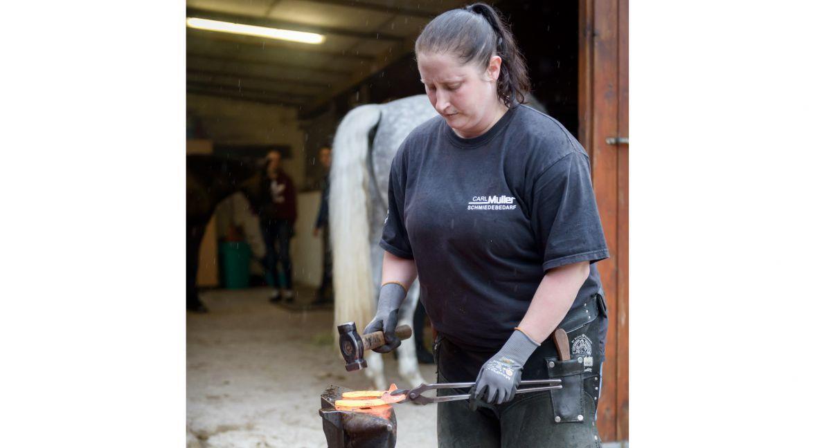 Jennifer Simmat aus Bremerhaven bringt mit Hammer und Amboss ein Hufeisen in Form.