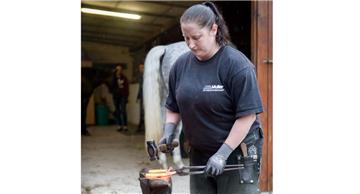 Jennifer Simmat aus Bremerhaven bringt mit Hammer und Amboss ein Hufeisen in Form.