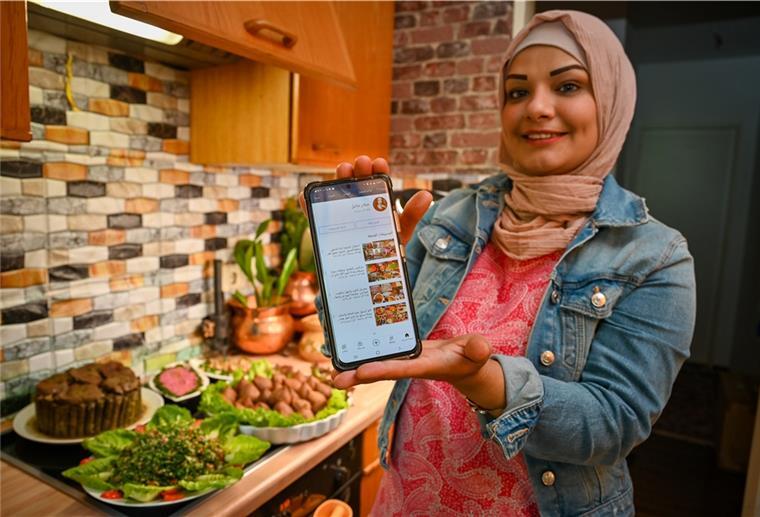 Jilhan Alhasan präsentiert in ihrer Küche auf einem Smartphone ihren YouTube-Kanal.