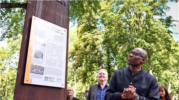 Joe Chialo (CDU), Berliner Kultursenator, betrachtet die neu eingeweihte Mahn- und Erinnerungsstele am ehemaligen „Afrika-Haus“ in Berlin.