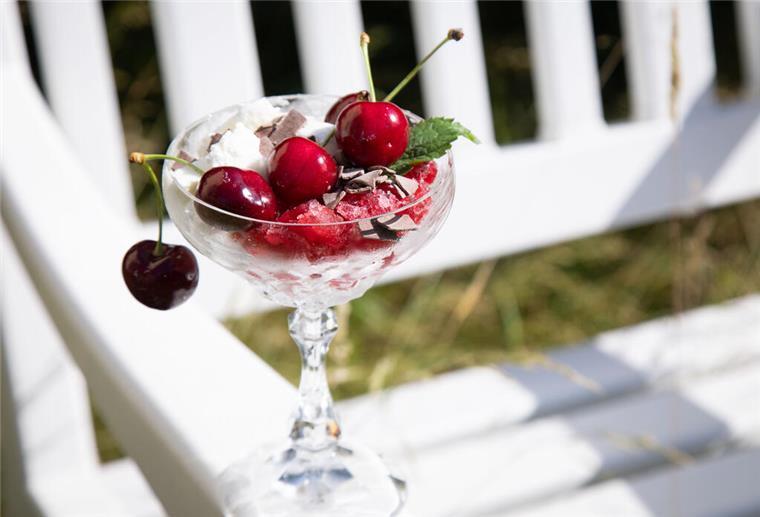 Cool bleiben bei Hitze: Diese Sommerdesserts sind echte Frische-Kicks Joghurt mit Wow-Faktor: Kratzeis von gefrorenem Joghurt ist die Basis, darüber kommt gekratzes Kirschsafteis, Schokoladenstreusel, Minze und frische Kirschen.