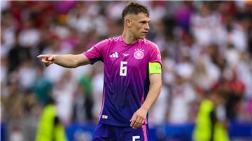 Joshua Kimmich zeigt auf dem Fußballplatz die Richtung an. 