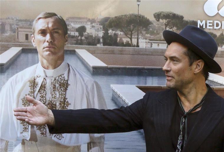 Jude Law vor einem Plakat mit sich als Papst Pius XIII. in der Serie „The Young Pope“. (Archivbild)